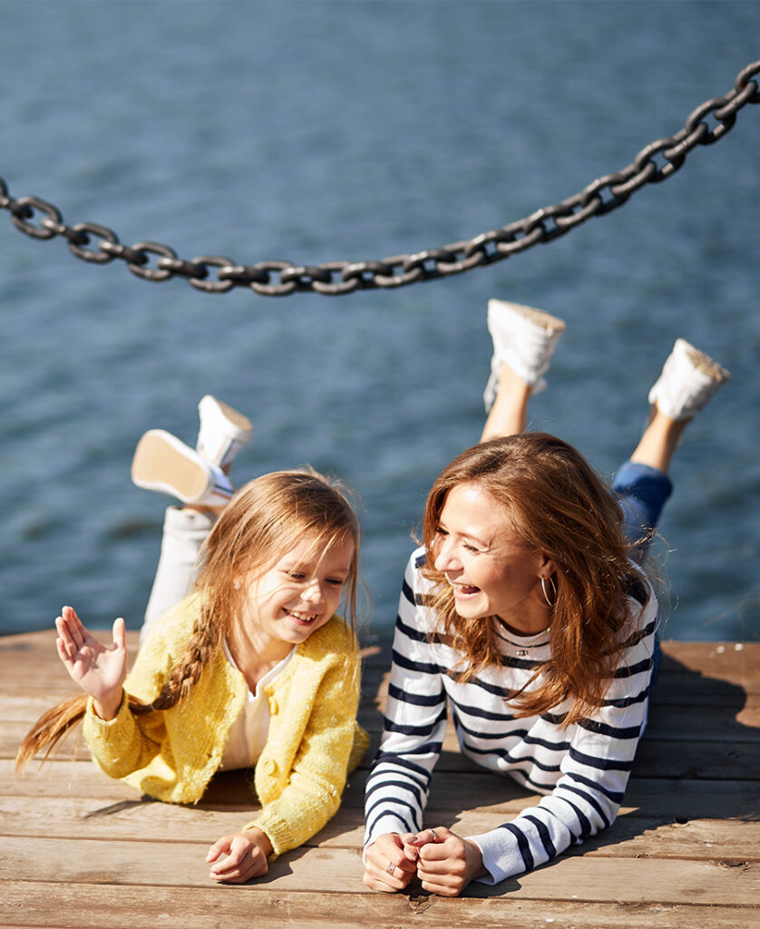 äiti ja tytär pitävät hauskaa laiturilla järven äärellä